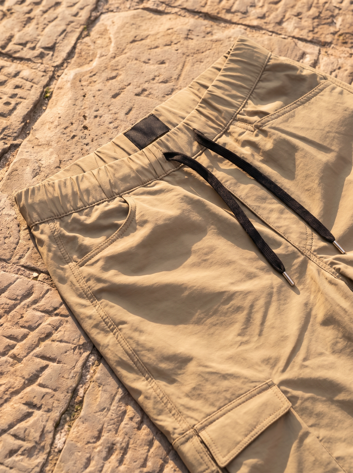 Khaki cargo pants, elastic waistband and black drawcord close-up