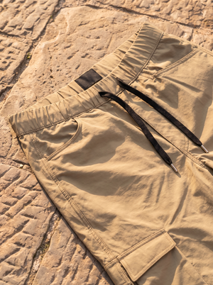 Khaki cargo pants, elastic waistband and black drawcord close-up